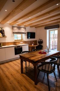 a kitchen with a wooden table and some chairs at Hochwertige Ferienwohnung Hochsitz in Saulgrub