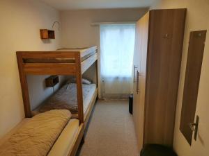 Cette petite chambre comprend 2 lits superposés et une fenêtre. dans l'établissement Casa Pignia, à Laax
