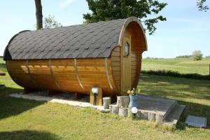 una grande casa hobbit in legno in mezzo a un campo di Peenehof Köppen - Schlaffässer Hannah oder Jette a Jördenstorf