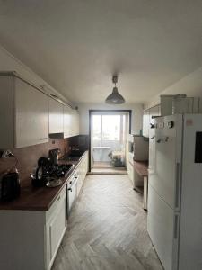 een keuken met een witte koelkast en een fornuis bij La cabane in Fontaine