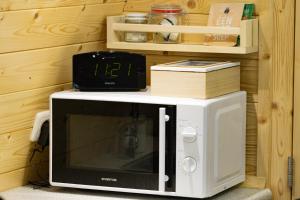 a microwave with a clock on top of it at Camping pod: Lyts Dekema 2 in Baard