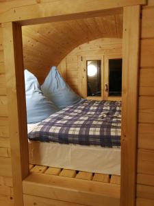 un letto all'interno di una cabina in legno di Peenehof Köppen - Schlaffässer Hannah oder Jette a Jördenstorf
