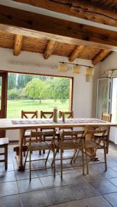 a large wooden table in a room with a large window at Chacra Esaki in El Bolsón