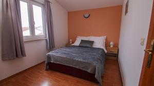 een slaapkamer met een bed en een raam bij Jacqueline Apartment in Pula