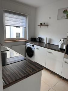 eine Küche mit einer Waschmaschine und einem Fenster in der Unterkunft Mondorf - klein aber fein zwischen Bonn & Köln in Niederkassel