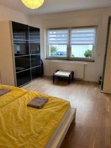 ein Schlafzimmer mit einem Bett mit einer gelben Decke darauf in der Unterkunft Mondorf - klein aber fein zwischen Bonn & Köln in Niederkassel