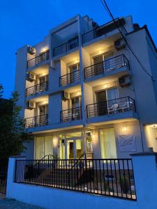 un edificio de apartamentos blanco con balcones por la noche en Vila Libra Costinesti, en Costinesti
