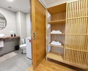 a bathroom with a toilet and a wooden door at Sleeping & Living Haro in Haro