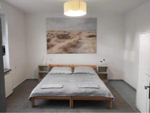 a bedroom with a bed and a painting on the wall at Seaside Holiday House in Gdańsk