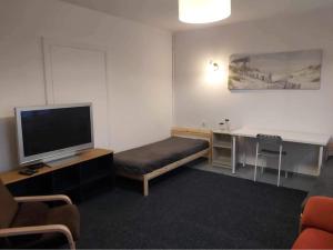 a room with a bed and a desk with a television at Seaside Holiday House in Gdańsk
