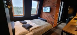 a bedroom with a bed and a brick wall at Apartman WINTER in Pale