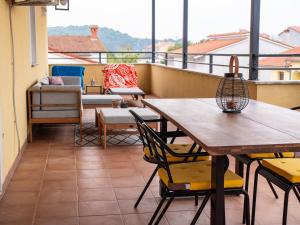 een balkon met tafels en stoelen en een bank bij Jacqueline Apartment in Pula