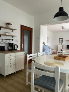 a kitchen with a white table and chairs in a room at Holiday Home Villa Emma in Debeljak