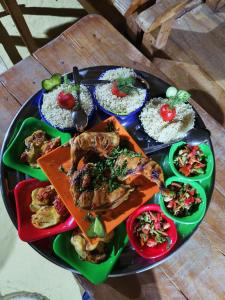 a plate of food on a table with rice at flamingo camp in Dār as Salām +63 photos