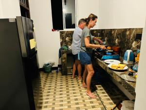 Royal Palace Mirissa في ميريسا: شخصان يقفان في مطبخ يقوم بإعداد الطعام