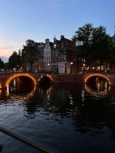 een brug over een rivier met gebouwen op de achtergrond bij Keizershouse Amsterdam in Amsterdam