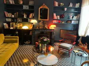 sala de estar con sofá amarillo y chimenea en Maison d'Hôtes " L'INSTANT D'AILLEURS" en Albi