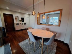 een eetkamer met een tafel, stoelen en een spiegel bij 2 habitaciones en piso Bilbao in Bilbao +25 foto's