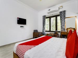 a bedroom with a bed and a desk and a television at Star Inn Plus in Kovalam