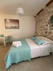 um quarto com uma cama e uma parede de pedra em Violet em Vis
