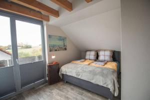 ein Schlafzimmer mit einem Bett und einem großen Fenster in der Unterkunft Odenwaldblick in Lützelbach