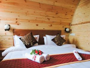 two beds in a room with wooden walls at Royal Adventures in Kodaikānāl