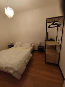 um quarto com uma cama, uma prateleira e um lustre em Auberge du Vieux Moulin em Le Breuil