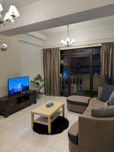 a living room with a couch and a tv at Riverview Home @Waterfront KCH in Kuching