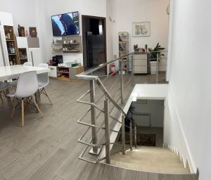 a staircase in a living room with a table and chairs at Gemasoti House in Drobeta-Turnu Severin