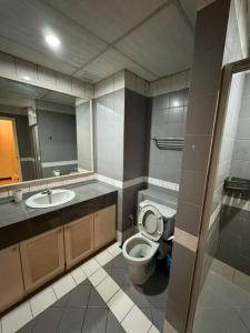 a bathroom with a toilet and a sink and a mirror at Riverview Home @Waterfront KCH in Kuching