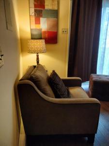 a couch sitting in a living room with a lamp at Family Cozy House in Frederick