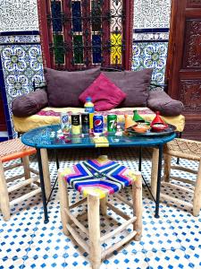 une table et un canapé avec une table et une chaise dans l'établissement RIAD TENDANCE IN MARRAKECH, à Marrakech