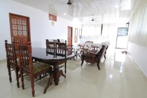 a room with chairs and a table and a dining room at Beena Homestay in Fort Kochi
