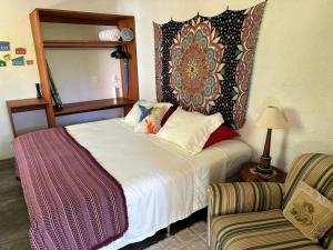 Un dormitorio con una cama, un espejo y una silla. en CasAmar Pé na Areia em Condomínio Beira Mar, en Serra Grande