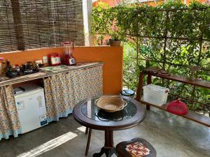 uma cozinha com uma mesa e um balcão com um fogão em CasAmar no Condomínio Beira Mar Sargi, Serra Grande em Serra Grande