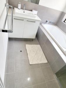 a bathroom with a sink and a tub and a toilet at Comfort oasis family getaway in Henley Brook