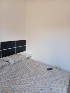 a bedroom with a bed with a black book on it at Apartamento Luxo em Vespasiano in Vespasiano