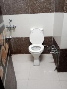 a bathroom with a white toilet in a stall at Hotel Parvati Residency in Sītāpur Mūāfi