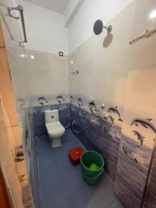 a bathroom with a toilet and a shower and a bucket at Hotel Parvati Residency in Sītāpur Mūāfi
