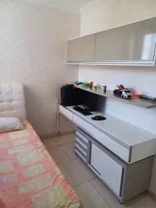 - une cuisine avec un comptoir blanc et des voitures jouets dans l'établissement Apartamento Luxo em Vespasiano, à Vespasiano
