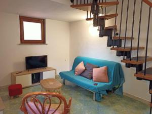 een woonkamer met een blauwe bank en een tv bij Casa blu Arbatax con giardino e terrazza in Tortolì