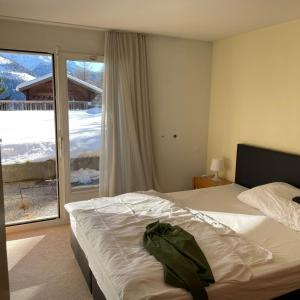 a bedroom with a bed and a large window at Residence Edelweiss in Bellwald