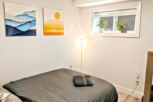 a white bedroom with a bed and a window at ENTIRE Garden Apt-Private Parking+Central Location in Vancouver