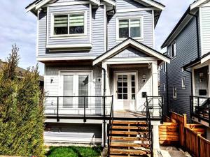 a white house with a porch and a balcony at ENTIRE Garden Apt-Private Parking+Central Location in Vancouver