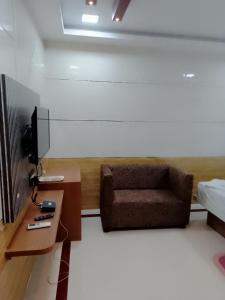 - un salon avec un canapé et une télévision dans l'établissement Hotel Ms Venture, à Bhubaneswar