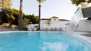a swimming pool with a water fountain at Villa Dune, Luxury Villa, 5 min walk to the beach in Marbella