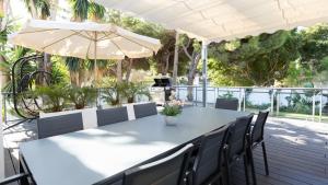 a table with chairs and an umbrella on a deck at Villa Dune, Luxury Villa, 5 min walk to the beach in Marbella