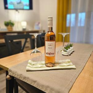 a bottle of wine sitting on a table with two glasses at Apartman Stefany in Varaždin