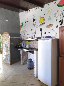 eine Küche mit einer weißen Wand mit Aufklebern darauf in der Unterkunft Jambudvipa Hostel in Natal