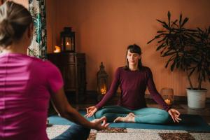 a woman sitting on the floor in a yoga pose at Retreat am See in Leipzig